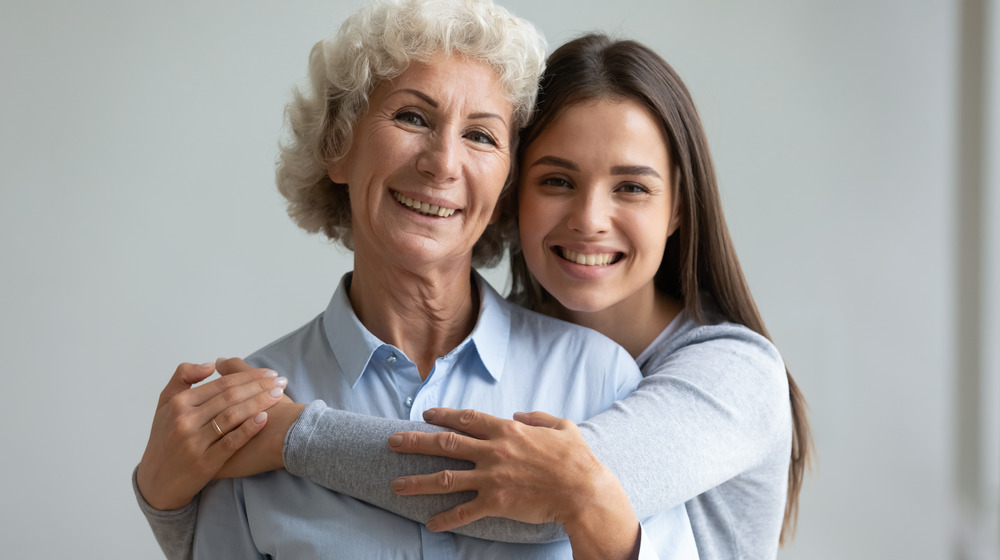 mother and daughter smiling, hugging